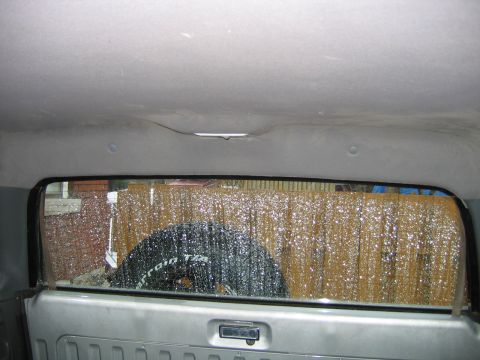1992 Ford Bronco - The interior of a vehicle is seen through the rear window, with a spare tire visible.
