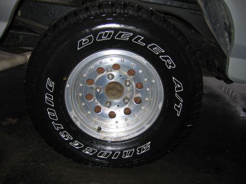 1992 Ford Bronco - Close-up of a Bridgestone Dueler A/T tire mounted on an aluminum wheel.