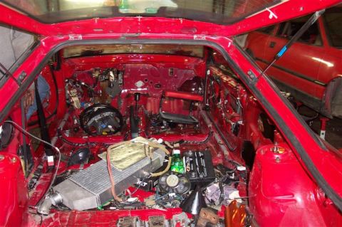 1994 Ford Probe - The interior of a red car is stripped bare, revealing its internal components and wiring.