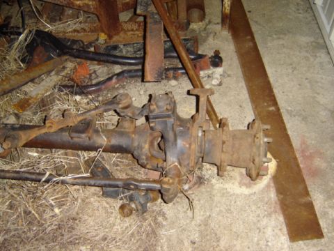 1992 Ford Bronco - A rusty front axle assembly with visible steering linkage components is shown, likely a spare part.