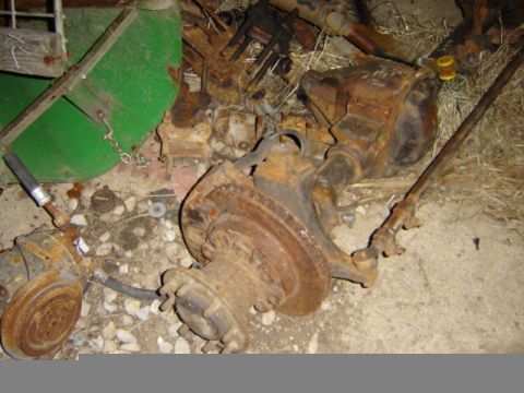 1992 Ford Bronco - Scrap metal heap includes heavily rusted vehicle axle and suspension parts.