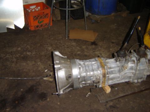 1992 Ford Bronco - Manual transmission with dual shifters resting on a concrete floor, possibly in a garage or workshop.