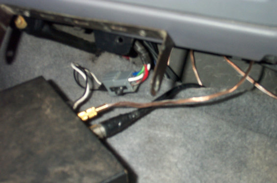 Under-dash wiring with colored connector and copper wires above carpet