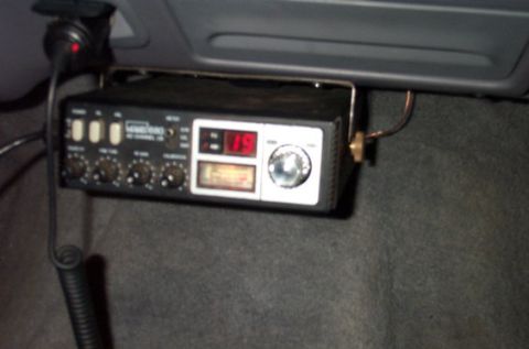 1995 Ford Bronco - A black 40-channel CB radio mounted under a dash or on carpeted trim, with a red digital channel readout showing '15', a signal meter, cont…