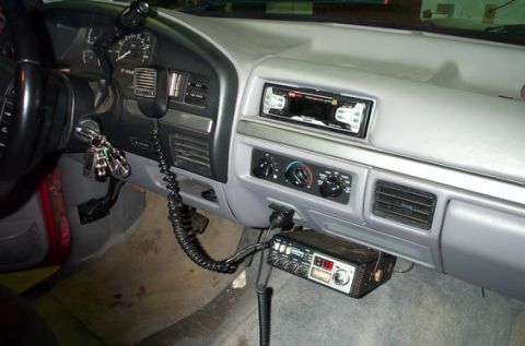 1995 Ford Bronco - Interior dashboard view of a Ford truck/SUV showing gray trim, an aftermarket radio, HVAC controls with a red/blue temperature dial, center…