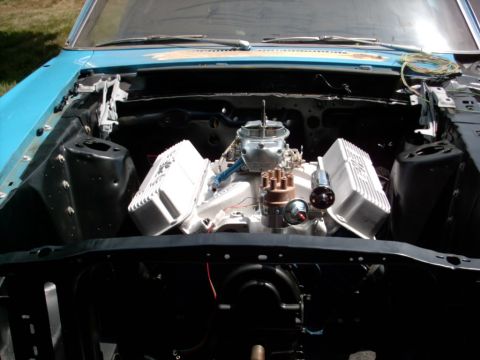 1986 Ford Bronco - V8 engine installed in the engine bay of a blue vehicle, showing carburetor and distributor.