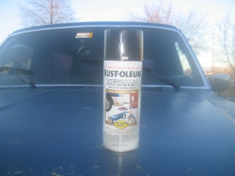 1981 Ford Bronco - A can of Rust-Oleum Metallic spray paint rests on the hood of a blue vehicle.