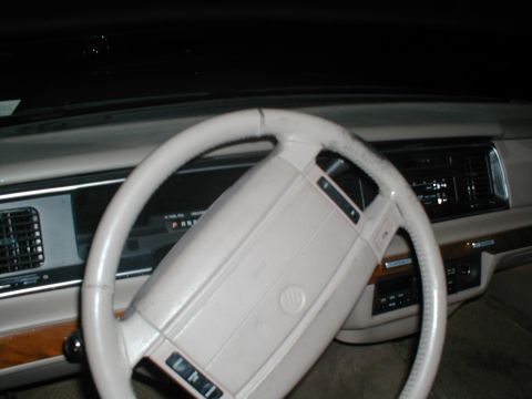 1979 Ford Bronco - Interior view of a car's dashboard and steering wheel, showing wood trim and radio controls.