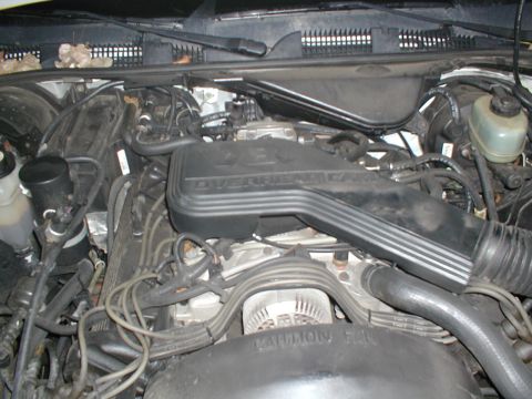 1979 Ford Bronco - Close-up view of a vehicle's engine bay, showing the overhead cam cover and alternator.