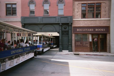 1990 Ford Bronco - Universal Studios tour tram passes a brick studio-backlot street facade marked Boulevard Books.