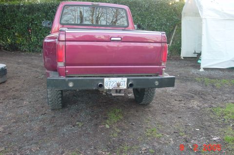 1992 Ford F-150 - Rear view of a red 1992 Ford F-150 pickup truck, dual exhaust pipes and a heavy-duty bumper.