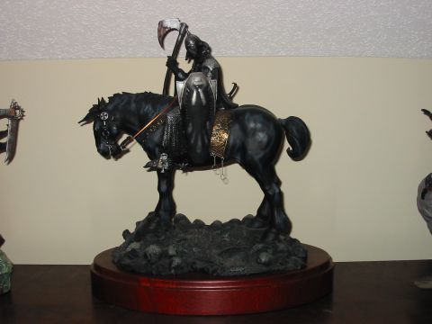 1991 Ford Bronco - A statue depicting the grim reaper riding a black horse, holding a scythe and shield, displayed on a wooden base.