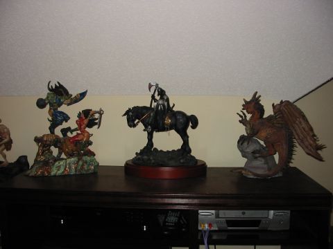 1991 Ford Bronco - A collection of fantasy figurines, including a dragon and a warrior on horseback, are displayed on a shelf.