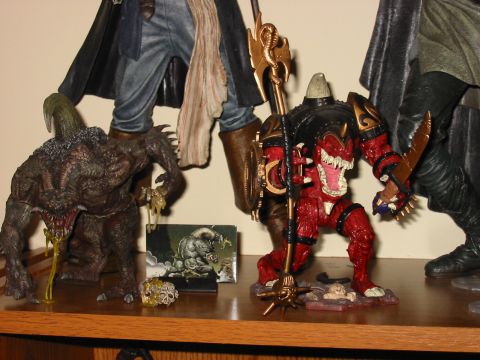 1991 Ford Bronco - A display of detailed fantasy action figures, including a red demon-like creature and a dark, horned monster.