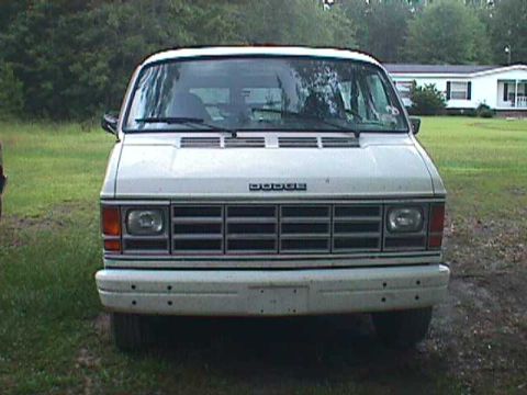 1994 Ford Crown Victoria - White Dodge van with a prominent grille and headlights, seen from the front.