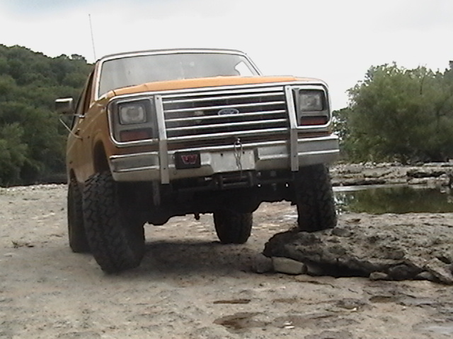 Orange 1986 Ford Bronco front view with chrome grille and bull bar