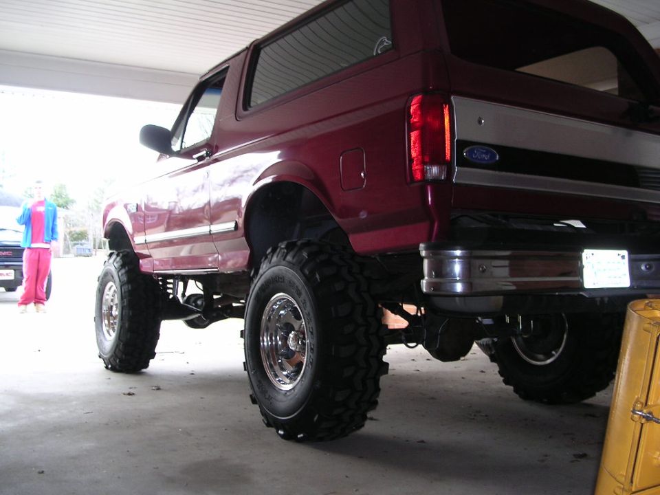 Red Ford Bronco, lifted with large tires, viewed from rear