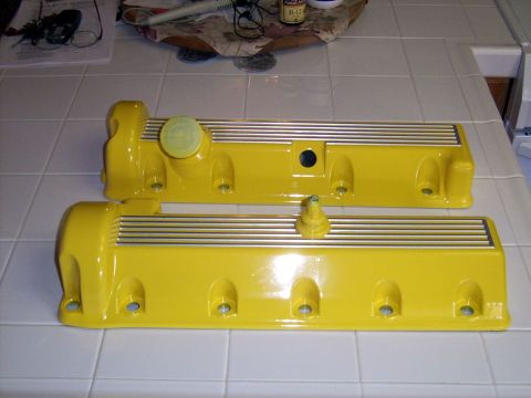 2002 Ford Mustang - Two yellow valve covers are displayed on a tiled surface.