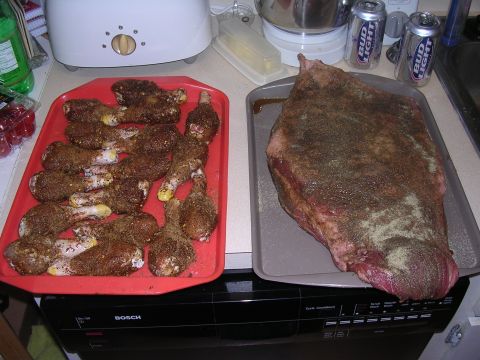 1985 Ford Bronco - Raw meat and chicken legs prepared with seasoning, ready for cooking.