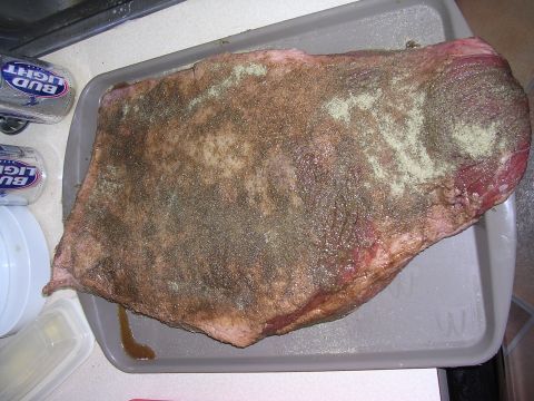 1985 Ford Bronco - A raw brisket, seasoned and ready for cooking, sits on a tray with two cans of beer nearby.