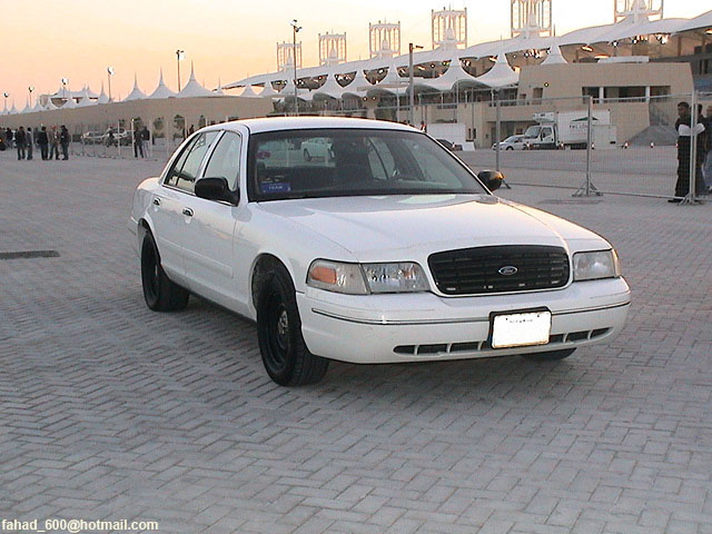 White sedan with black grille and black wheels parked on a paved surface