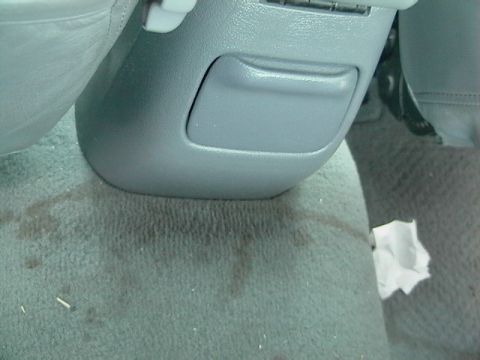 1995 Ford Contour - Close-up of a car's interior, showing the carpet and a storage bin.