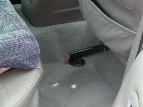 1995 Ford Contour - Close-up of a car's interior floor, showing carpet and seat mounting hardware.