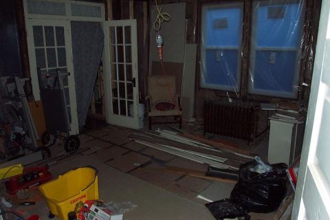 1985 Ford LTD Crown Victoria - Construction site interior with doors, windows, and a chair visible. Tools and debris are scattered around the room.