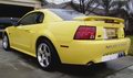 2002 Ford Mustang - Rear view of a yellow 2002 Ford Mustang parked in a driveway.