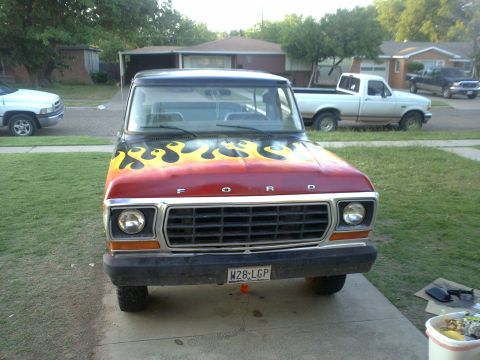 1978 Ford Bronco - Front view of a 1978 Ford Bronco flame decals on its hood, with other vehicles in the background.