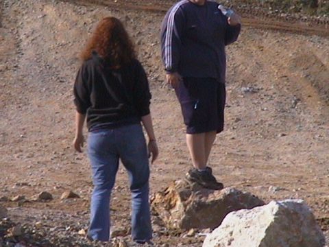 1991 Ford Bronco - Two individuals are standing in a rocky, dirt area. One person is holding a bottle of water.