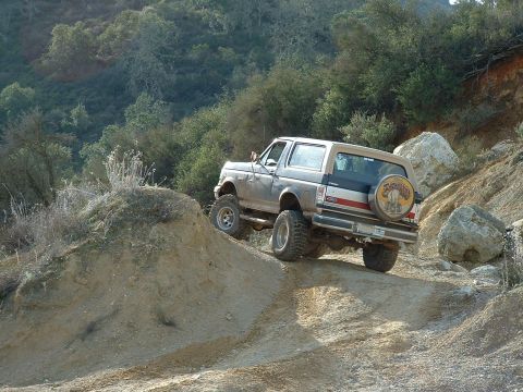 1991 Ford Bronco - This 1991 Ford Bronco navigates a challenging off-road trail with steep inclines and rocky terrain.