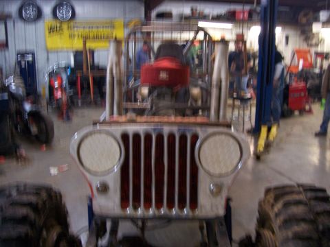 1999 Jeep TJ - Front view of a modified Jeep CJ with prominent exhaust pipes and a red air intake.