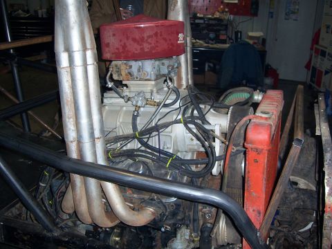1999 Jeep TJ - Close-up view of a modified engine assembly, including a supercharger and prominent exhaust pipes.