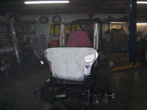 1999 Jeep TJ - A 1999 Jeep TJ is seen in a garage, partially covered with a white sheet and a red cloth.