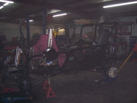1999 Jeep TJ - A custom buggy frame is being worked on in a garage, supported by jack stands.