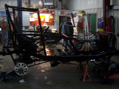 1999 Jeep TJ - A custom buggy frame, likely undergoing modification or construction, is shown in a workshop setting.