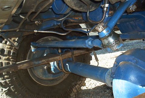 1986 Ford Bronco - Close-up of a vehicle's undercarriage, focusing on the suspension and tire.
