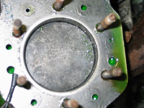 1990 Ford Mustang - This is a close-up view of an engine cylinder, showing pooled green fluid around the mounting bolts.