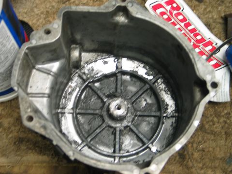 1990 Ford Mustang - This is a close-up view of a greasy engine component, possibly a housing or cover, with visible wear and tear.