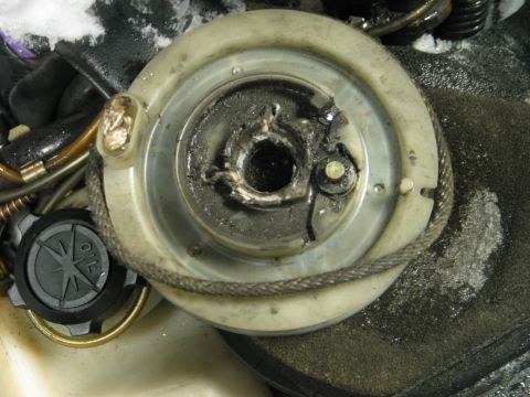 1990 Ford Mustang - Close-up of a damaged snowmobile recoil starter assembly, showing wear and tear.