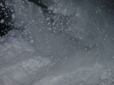 1990 Ford Mustang - A snowboarder kicks up snow while descending a mountain.