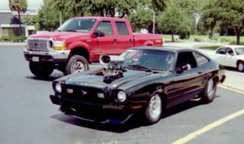 1978 Ford Mustang II - This modified black coupe, likely a 1975 Ford Mustang II, features a prominent blower protruding from the hood.