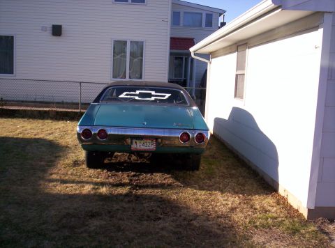 1971 Chevrolet Chevelle - Rear view of a teal 1971 Chevrolet Chevelle parked next to a white building.