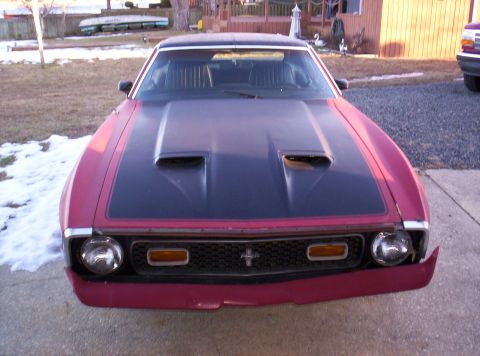 1971 Ford Mustang - Front view of a 1971 Ford Mustang with a black hood and red body panels.