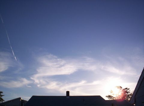1995 Ford Bronco - Sky with contrail and clouds over rooftops, with a website watermark at the bottom right.
