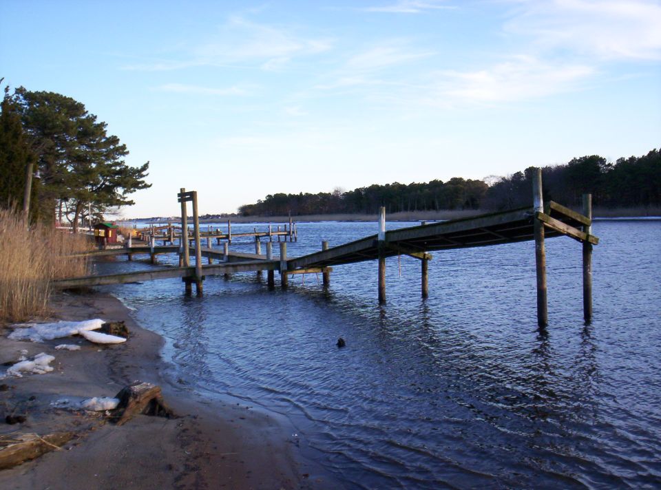 Wooden dock extending into blue water under a clear sky