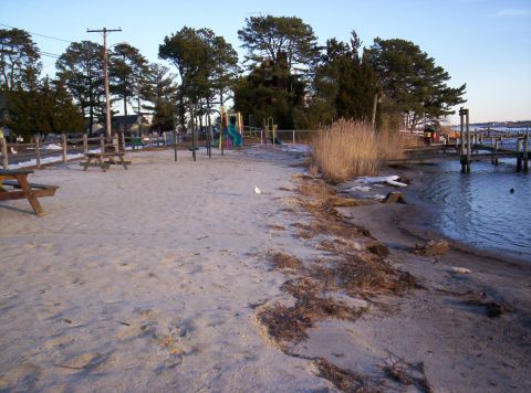 1995 Ford Bronco - A waterfront scene shows a sandy beach area with playground equipment and a wooden pier.