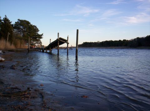 1995 Ford Bronco - Waterfront scene with a wooden dock and calm water under a partly cloudy sky.