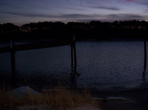 1995 Ford Bronco - A tranquil waterscape at dusk, a wooden dock and silhouetted trees against a twilight sky.